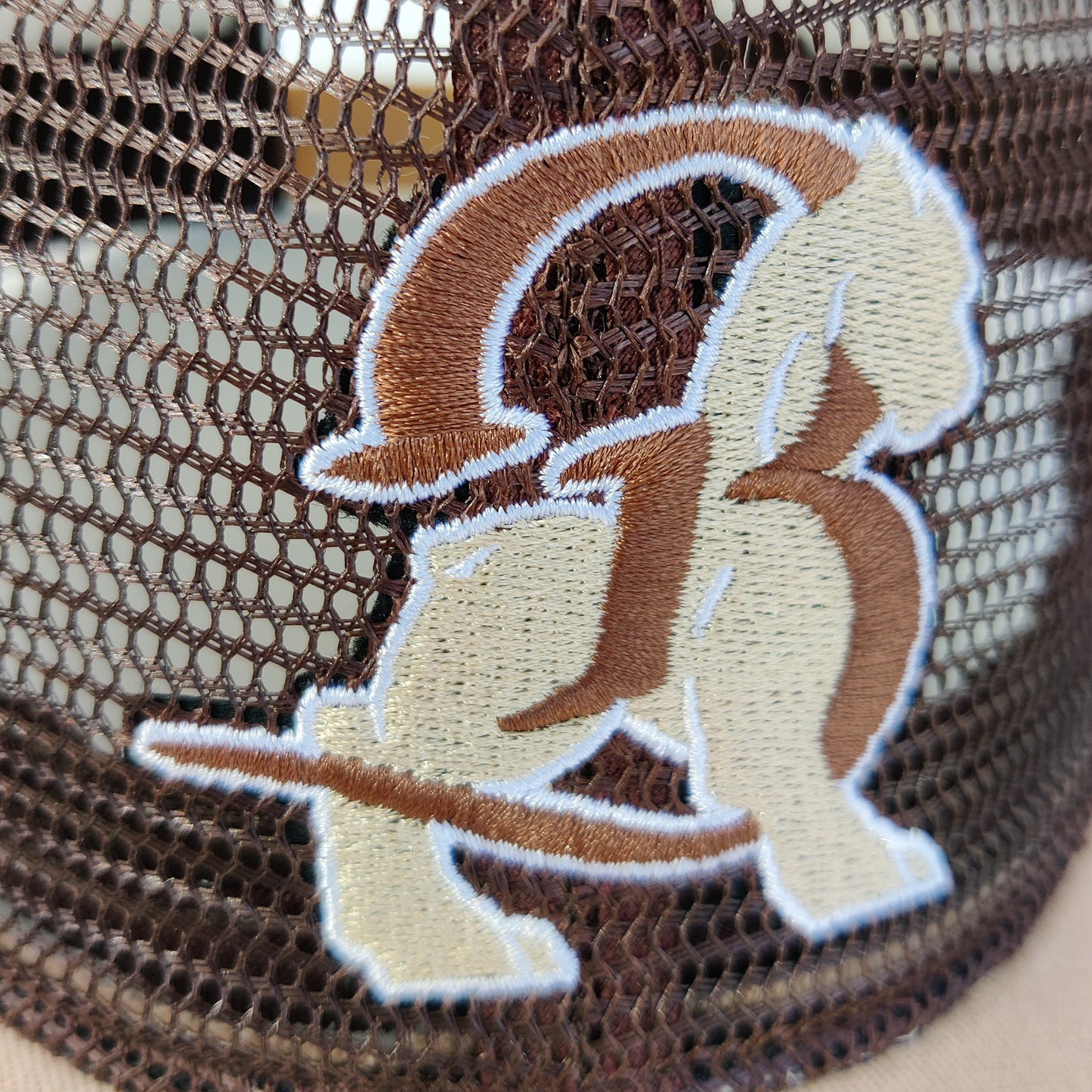 Gros plan sur la broderie frontale de la casquette trucker inversée Bahamut, le blason Bahamut.