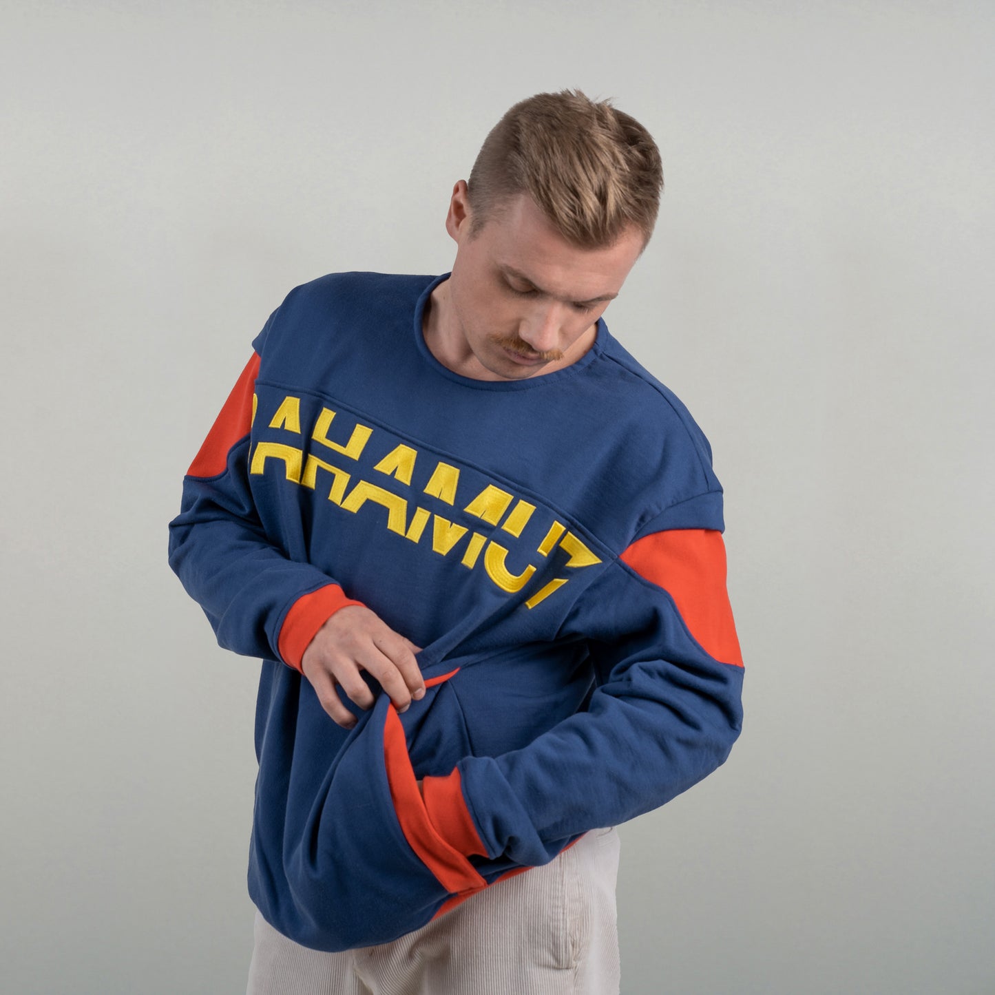 Le sweat est porté par un model masculin, vu de face. l'accent est mis sur la poche dissimulée.