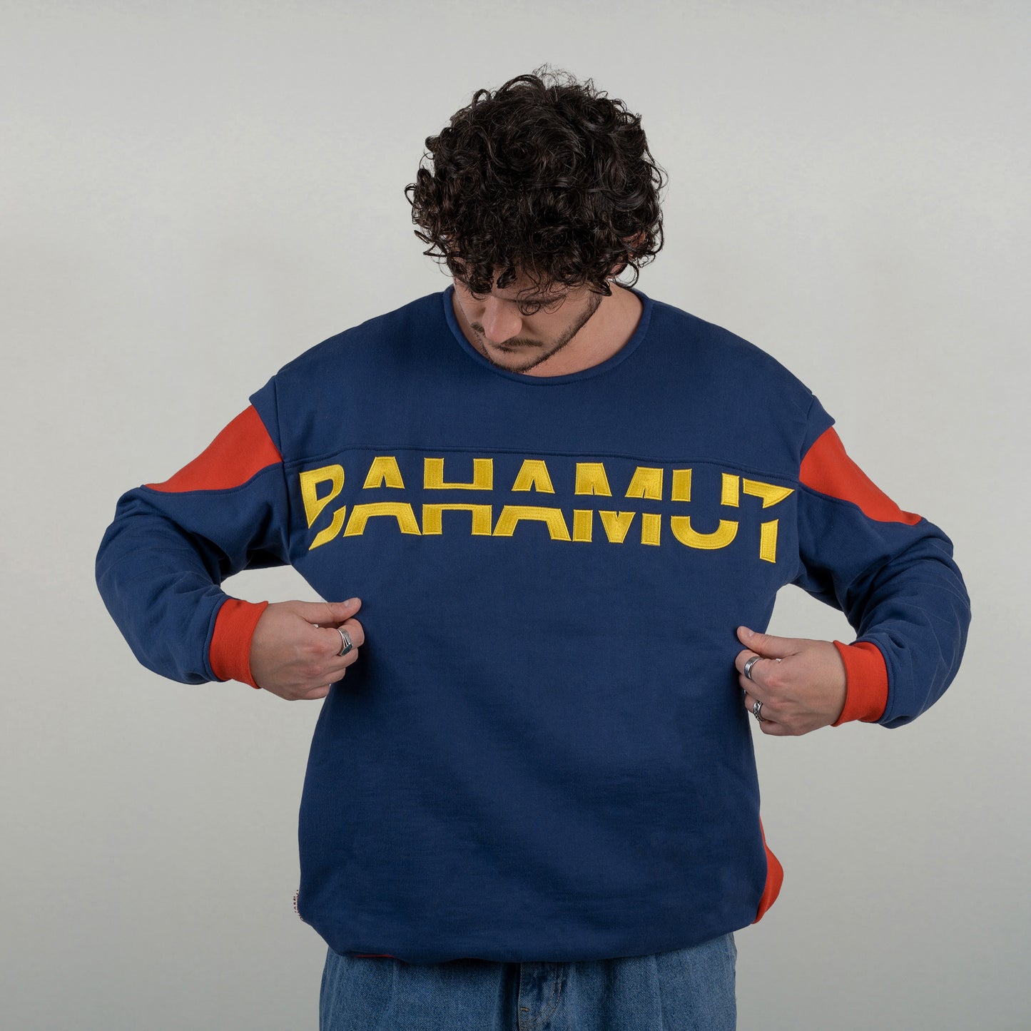Le sweat est porté par un model masculin. L'accent est mis sur la broderie XXL.