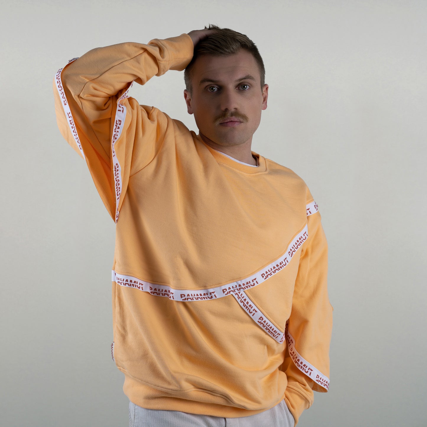 Le sweat est vu porté par un modèle masculin vu de face.