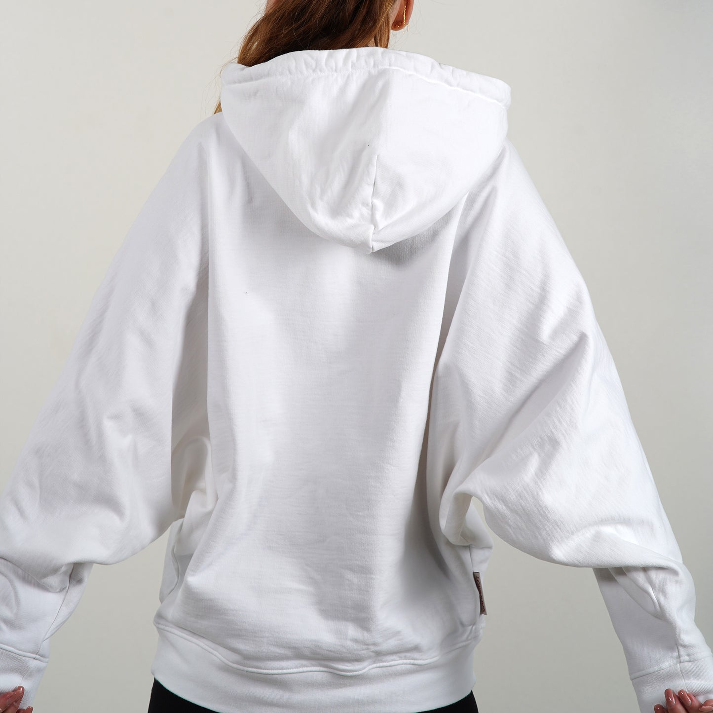 Le Hoodie chauve-souris Envol - N°1 est porté par un modèle féminin vu de dos.